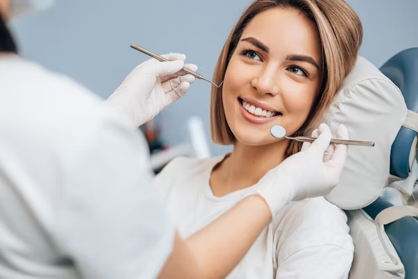 a woman smiling at the dental practitioner during a dental treatment
