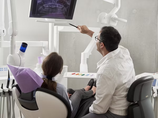 a dentist showing the patient their dental x-ray
