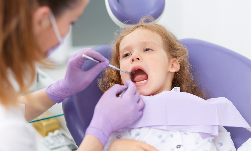pediatric dentist examining a young child during a routine dental checkup