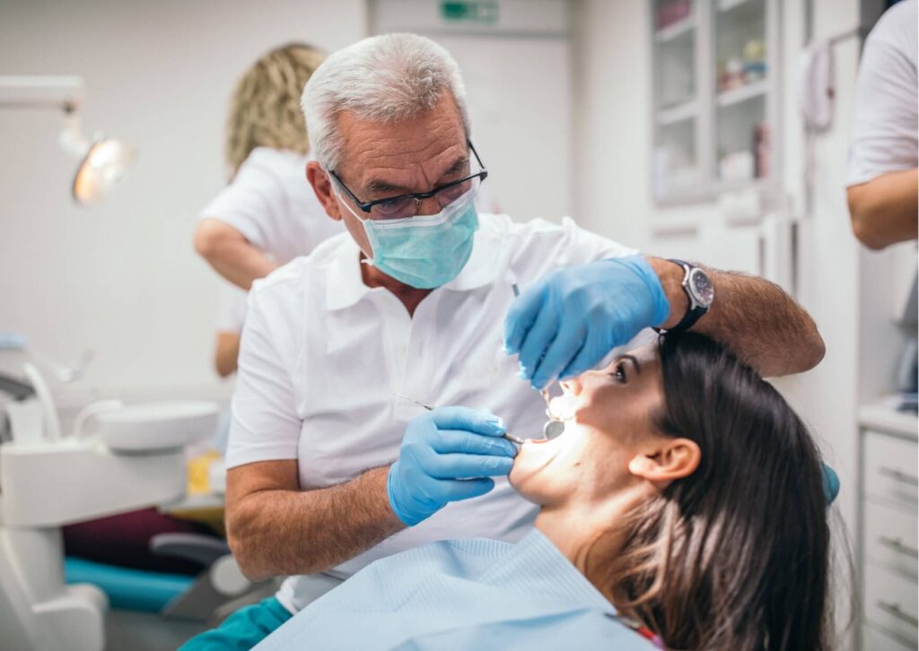 Dentist examining a patient's teeth for signs of tooth decay, highlighting the importance of professional treatment when a cavity cannot heal on its own.