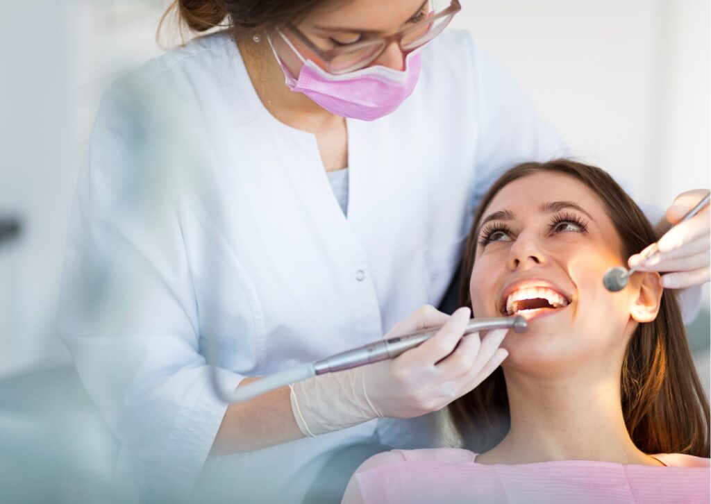 Dentist examining a patient's smile during a cosmetic consultation to discuss veneer costs by location and personalized treatment options.