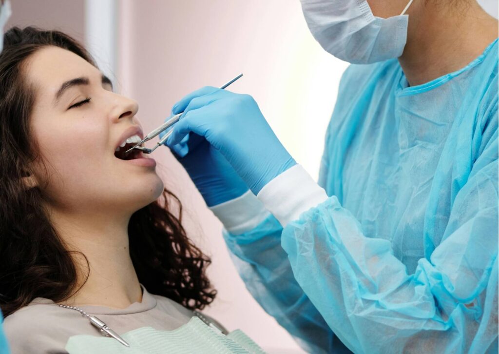 Dentist examining a patient's tooth during an oral exam to diagnose a cracked tooth and evaluate visible signs of tooth damage.