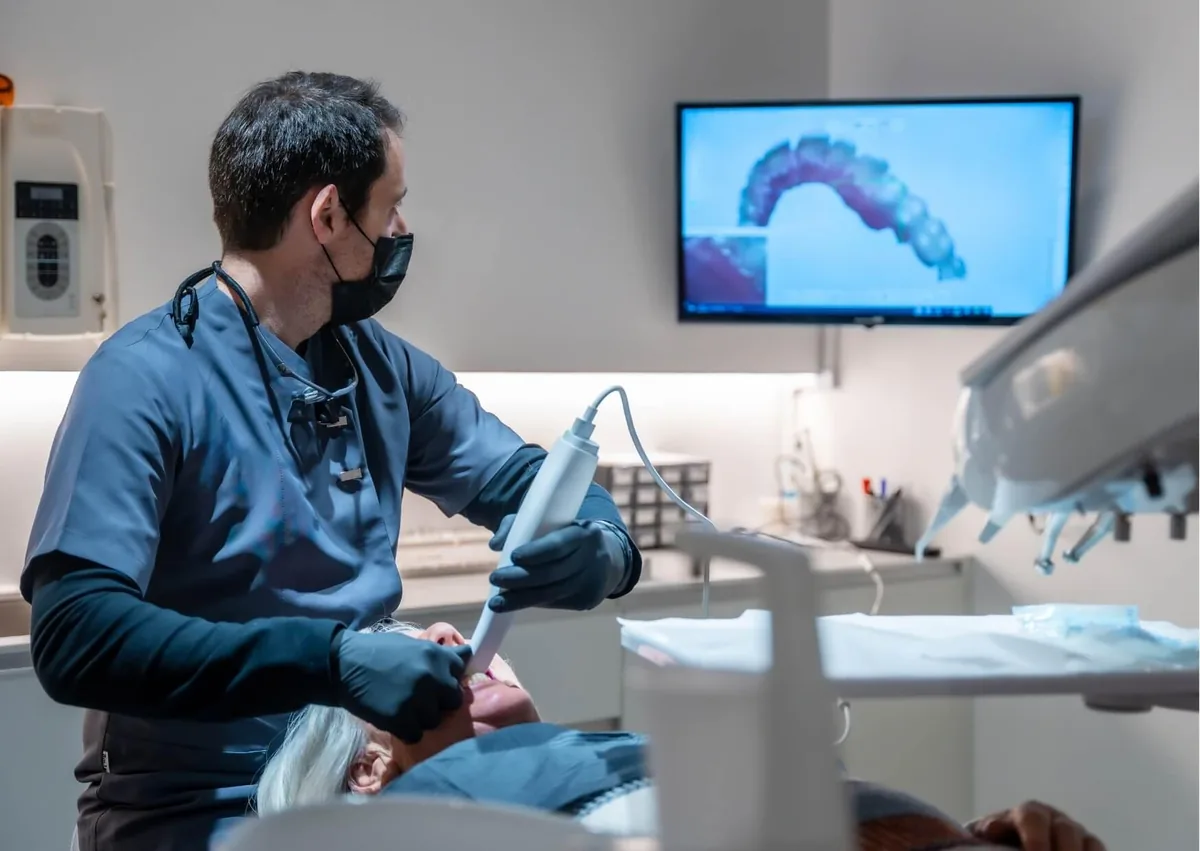 Dentist using digital scanning technology to plan full mouth dental implants for a patient.