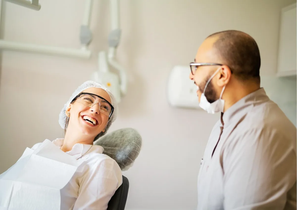 Patient smiling with a dentist after completing teeth bonding treatment.